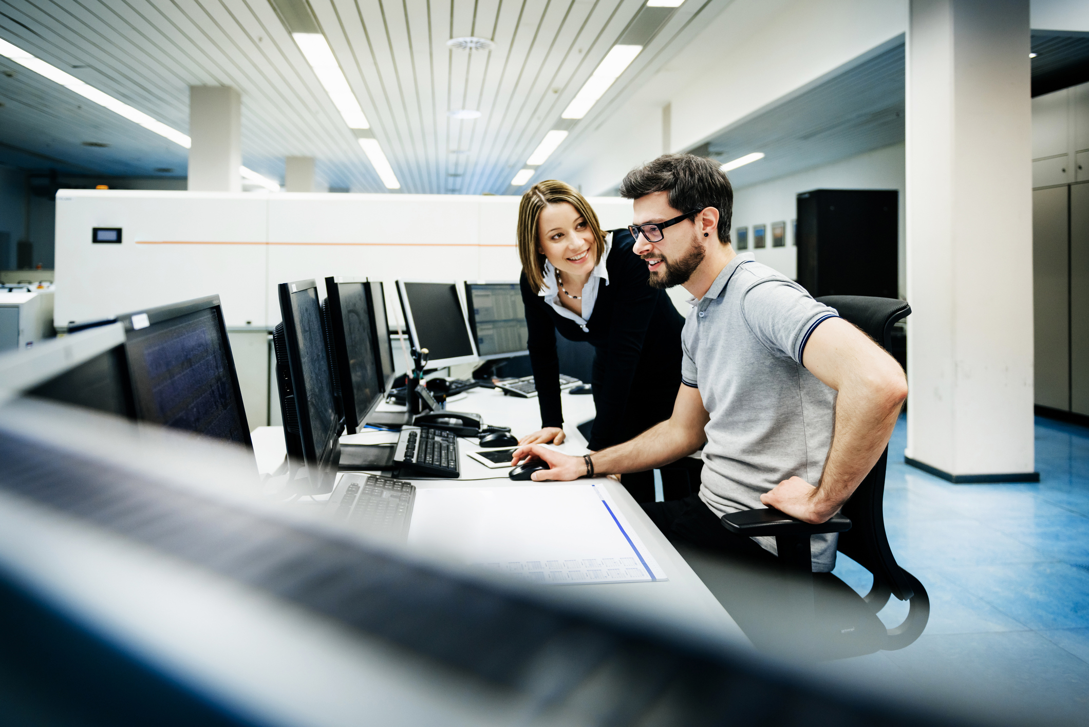 Two people looking at computer, one is helping the other