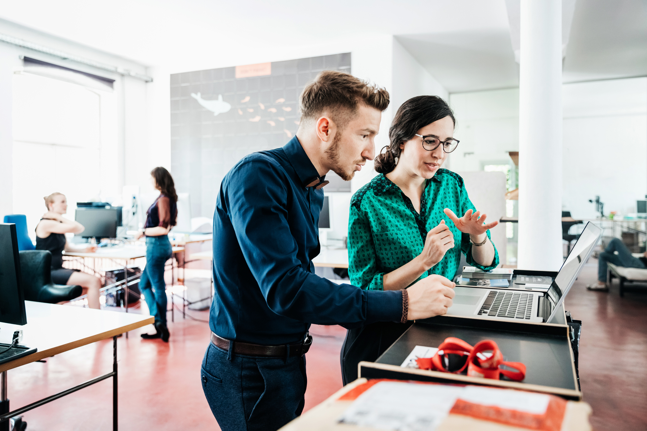 Two people in office looking at laptop